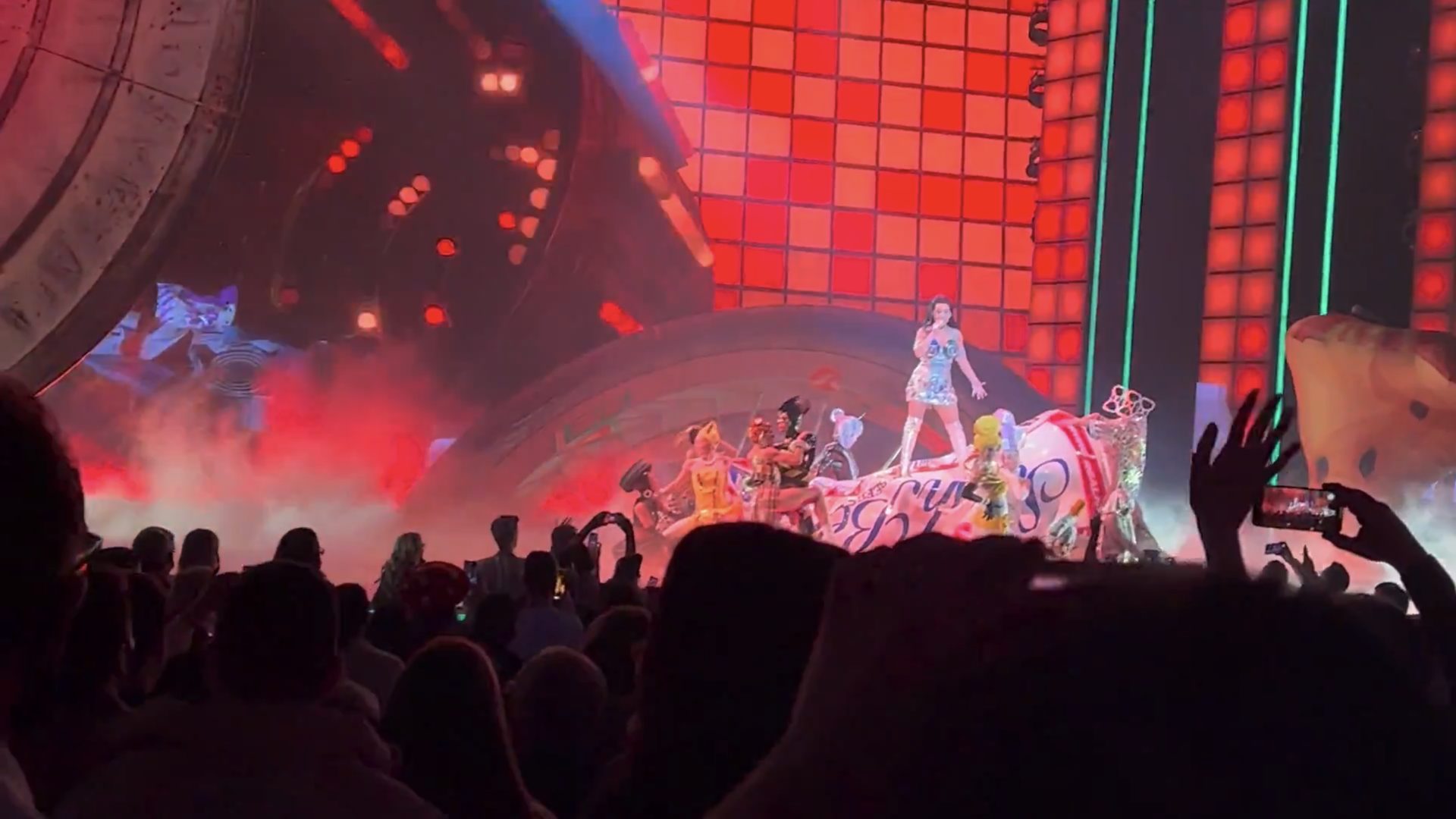 Katy Perry on stage in front of a glowing red grid on the screens