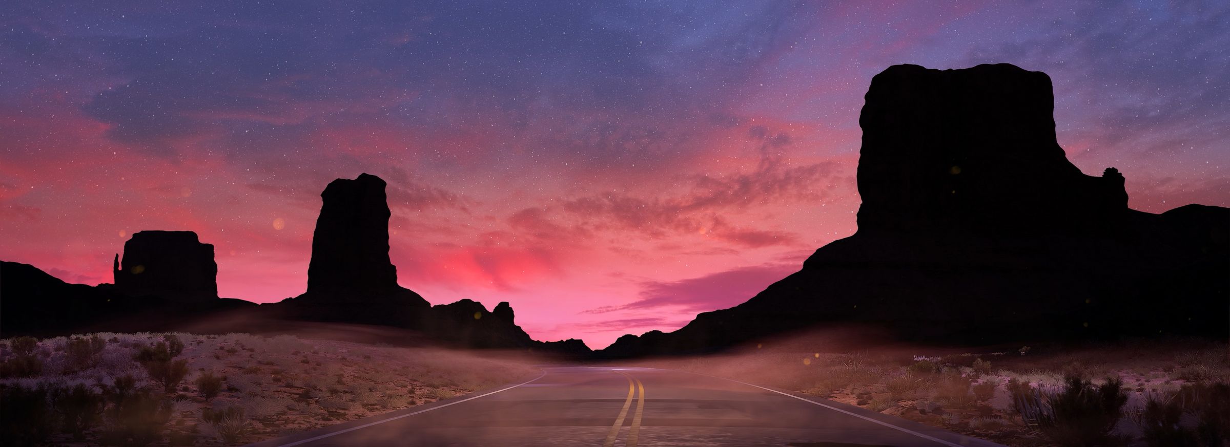 Desert buttes in silhouette under a starry pink dusk